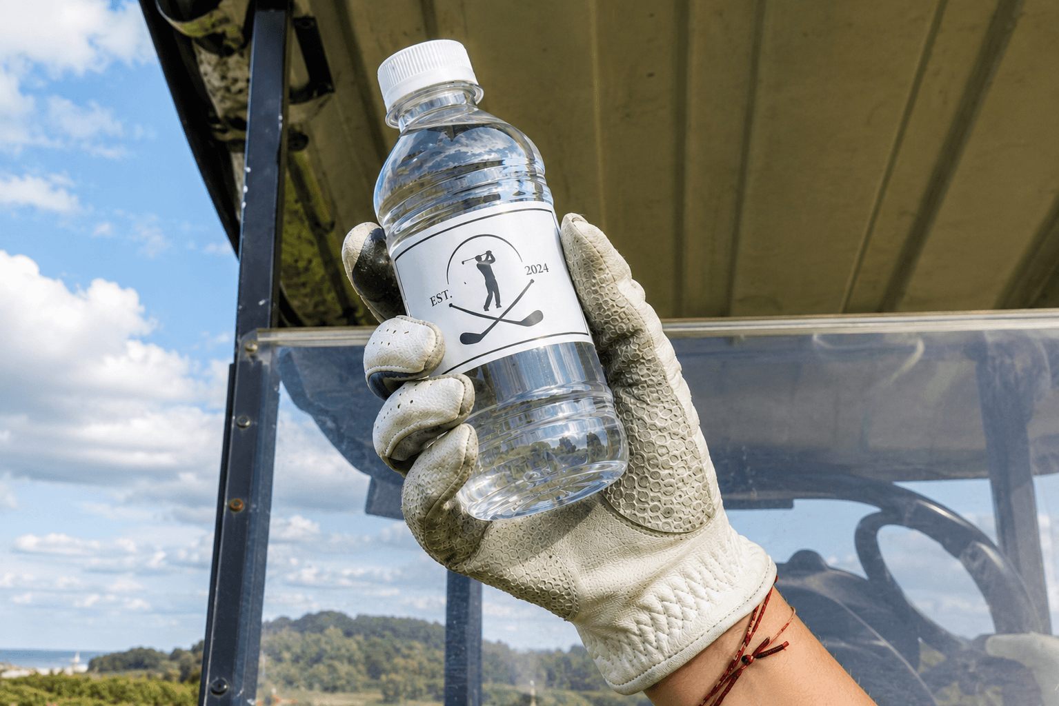Custom-labeled bottle in hand on a golf cart