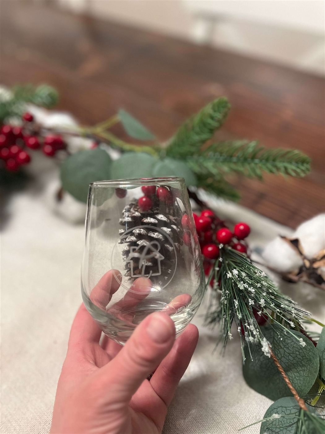 Engraved stemless wine glass held in hand